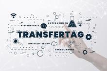 Schriftzug Transfertag mit verschiedenen Symbolen im Hintergrund eine zeigende Hand